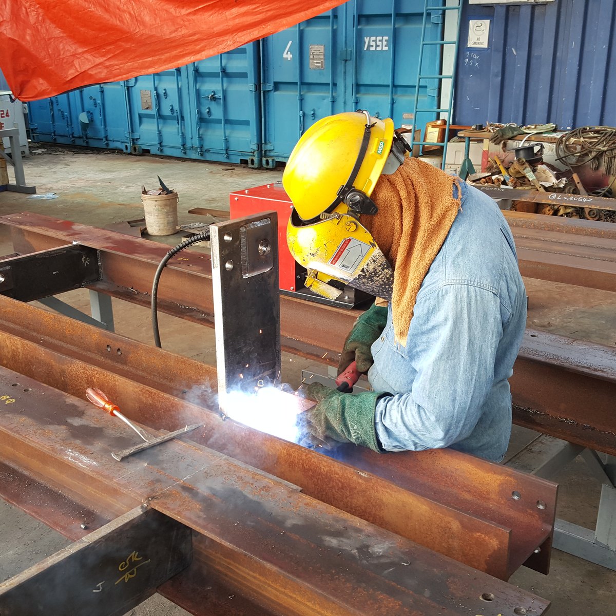 A welder joining a steel beam in the YSSE workshop in Kuching
