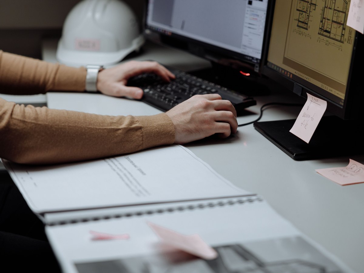 Drawings and a hard hat on a site office desk